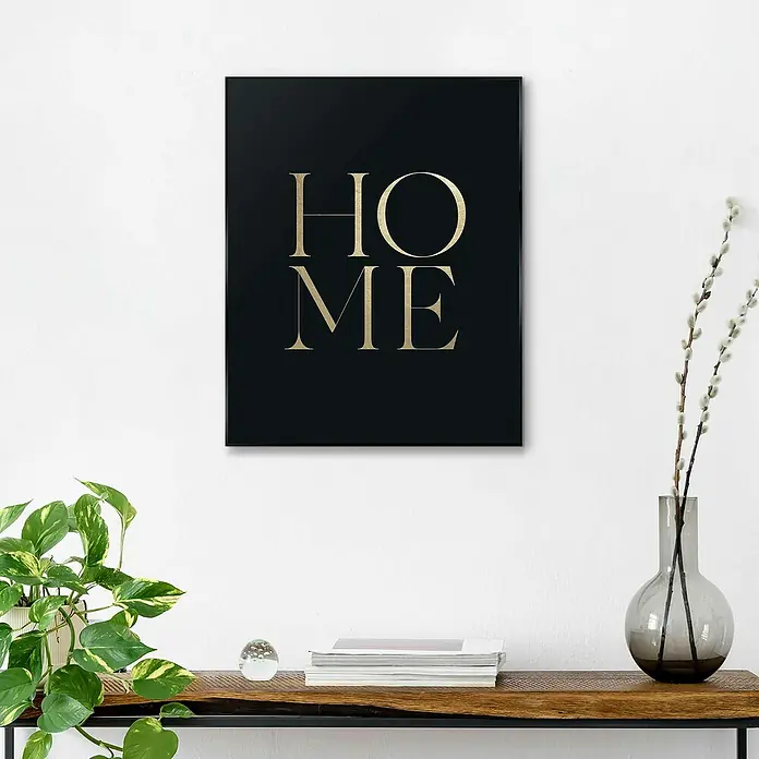 Reinders Bild Slim Frame Black - Home, B x H: 40 x 50 cm - Schwarzes Wandbild mit goldener Aufschrift "HOME" über einer Konsole mit Dekorationen.