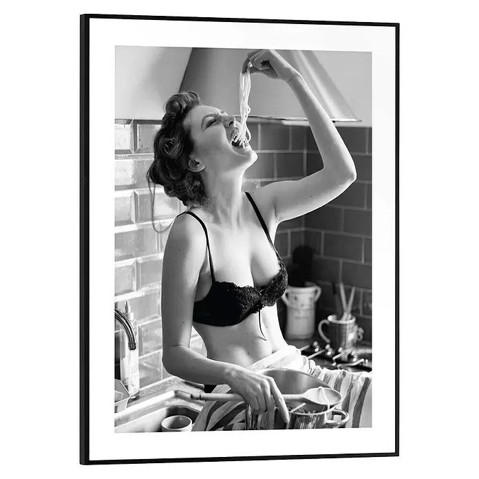 Reinders Bild Slim Frame Black - Pasta Lady, B x H: 30 x 40 cm - Schwarz gerahmtes Foto einer Frau in der Küche, die Spaghetti direkt aus einem Topf isst, in Schwarz-Weiß.