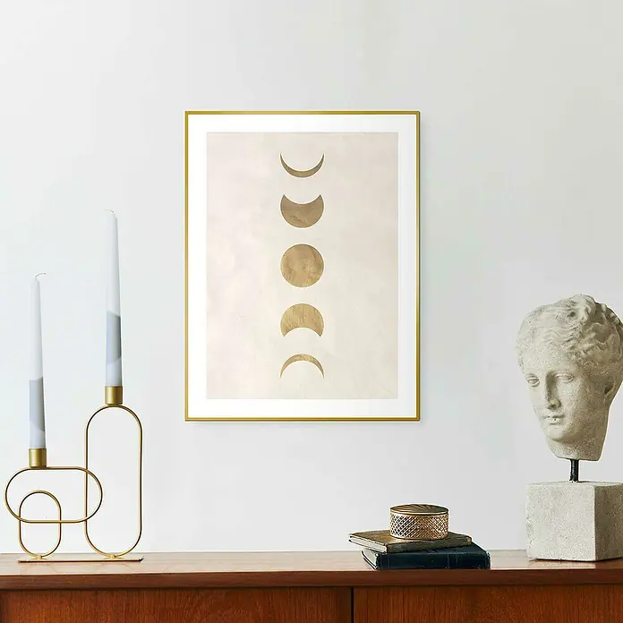 Reinders Bild Slim Frame Gold - Moonphases, B x H: 30 x 40 cm - Ein golden gerahmtes Mondphasen-Wandbild mit einem Kerzenständer und einer Büste auf einem Holzschrank.
