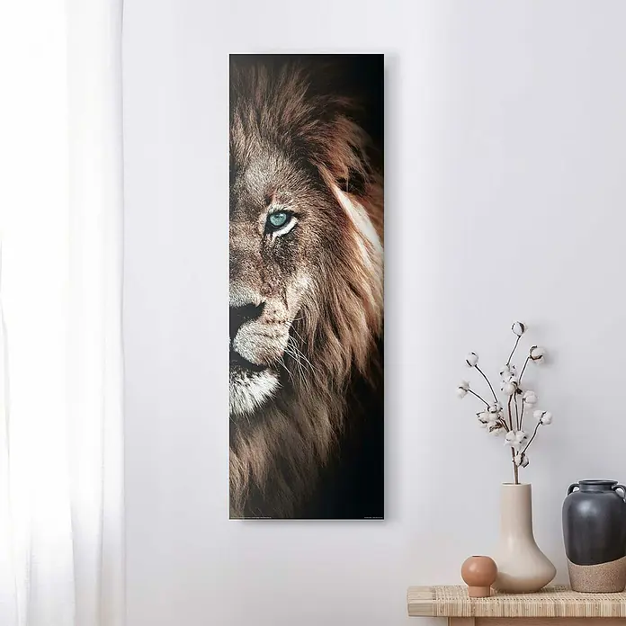Reinders Decopanel - Half Lion, B x H: 30 x 90 cm - Nahaufnahme eines Leinwandbildes mit einem Löwen, das an einer weißen Wand hängt. Dekoratives Element für ein modernes Zuhause.