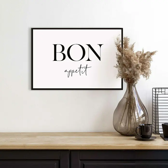 Reinders Bild Slim Frame Black - Bon Appetit, B x H: 30 x 20 cm - Ein gerahmtes "Bon appétit"-Poster hängt über einem Tisch mit einer Vase und einer Tasse, was eine elegante Küchen- oder Esszimmerdekoration darstellt.