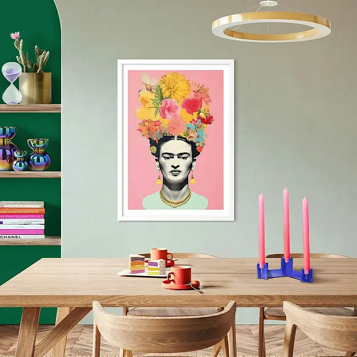 Reinders Bild Modern Frame - Freedom Flowers, B x H: 50 x 70 cm - Ein modernes Esszimmer mit einem Frida Kahlo-Kunstdruck, der über einem Holztisch mit rosa Kerzen und bunten Tassen hängt.