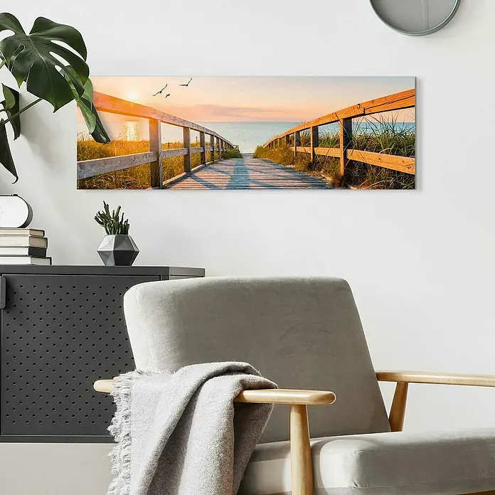 Reinders Decopanel - Beach Boardwalk, B x H: 90 x 30 cm - Wandbild "Holzsteg zum Strand" mit sanftem Sonnenuntergang, das eine ruhige Atmosphäre in den Raum bringt. Ideal über einem Sessel platziert.