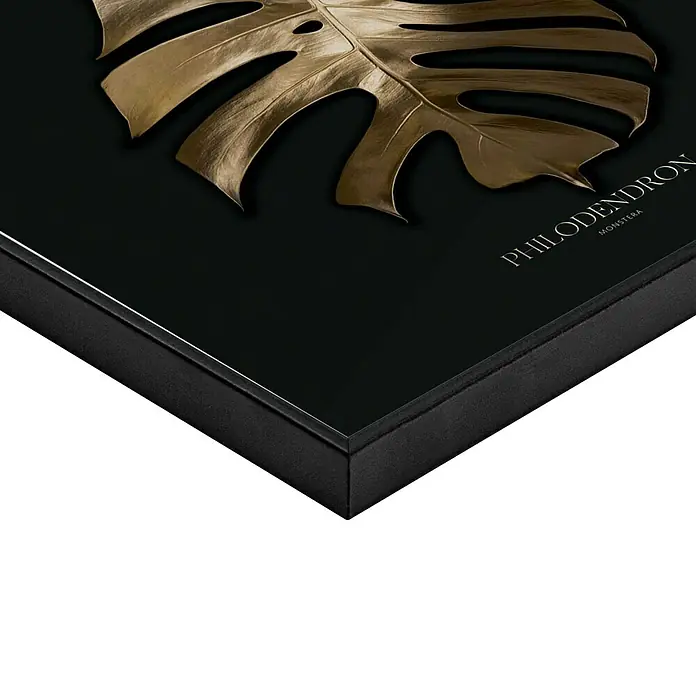 Reinders Bild Slim Frame Black - Monstera Gold, B x H: 50 x 50 cm - Nahaufnahme eines gerahmten Kunstwerks mit einem goldenen Monstera-Blatt auf schwarzem Hintergrund, das einen eleganten und modernen Touch verleiht.