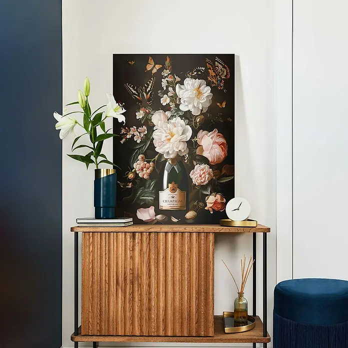 Reinders Leinwandbild Giclee on Canvas - Festive Flowers, B x H: 50 x 70 cm - Das Bild zeigt ein Champagnerflasche-Blumenstillleben auf einer Kommode mit einer blauen Vase und Dekorationsgegenständen.