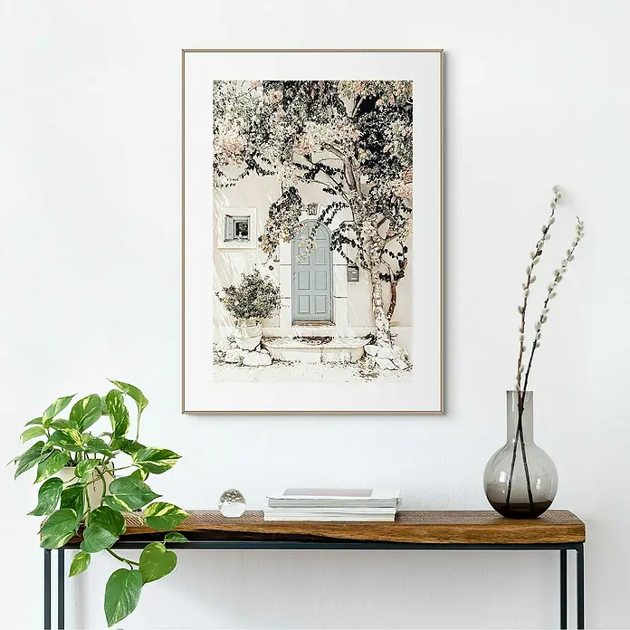 Reinders Bild Slim Frame Wood - Mediteran Door, B x H: 50 x 70 cm - Wandbild mit floralem Motiv über einer Konsole, die mit einer Pflanze, Büchern und einer Glasvase dekoriert ist.