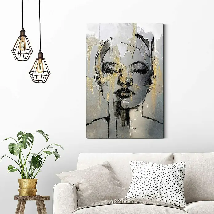 Reinders Decopanel - Golden Face, B x H: 60 x 90 cm - Elegantes Wandbild mit einer Frauendarstellung in Grau- und Goldtönen über einem stilvollen weißen Sofa und einer dekorativen Zimmerpflanze.