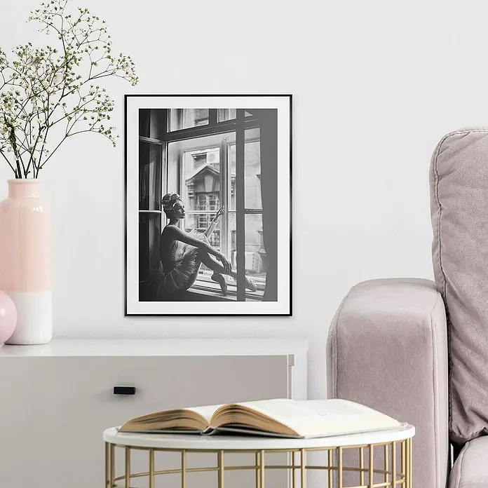 Reinders Bild Slim Frame Black - Daydreamer, B x H: 30 x 40 cm - Schwarzes gerahmtes Kunstwerk, das eine Ballerina am Fenster zeigt, hängt an einer weißen Wand über einem eleganten Sideboard und einem Beistelltisch.