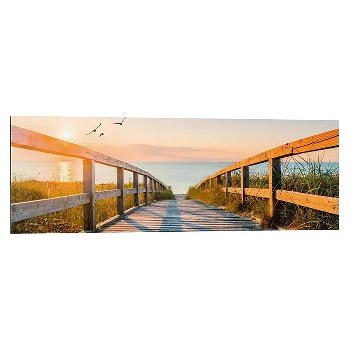 Reinders Decopanel - Beach Boardwalk, B x H: 90 x 30 cm - Ein Holzsteg führt durch Dünengras zum Meer bei Sonnenuntergang, getaucht in warmes goldenes Licht.