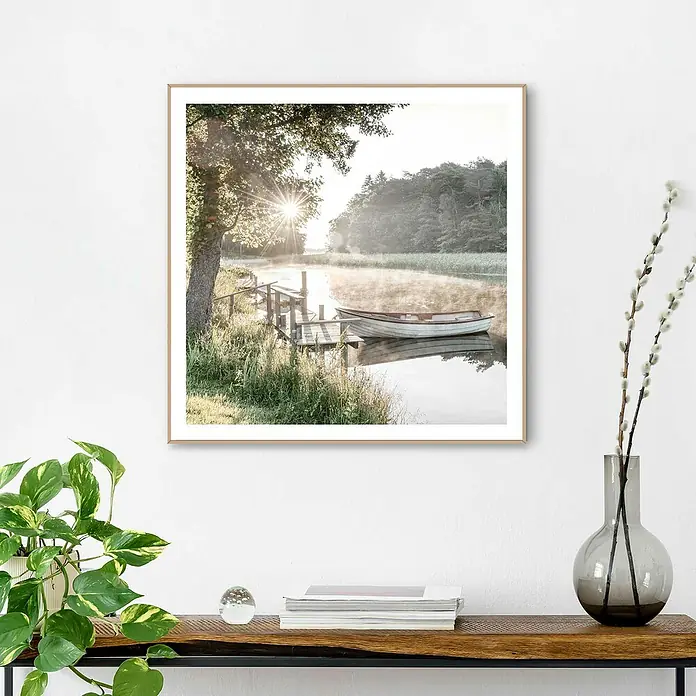 Reinders Bild Slim Frame Wood - Rise and Shine, B x H: 50 x 50 cm - Gerahmtes Kunstwerk mit einer Szene eines Sees bei Sonnenaufgang, mit einem kleinen Boot an einem Dock, das die friedliche Atmosphäre betont.