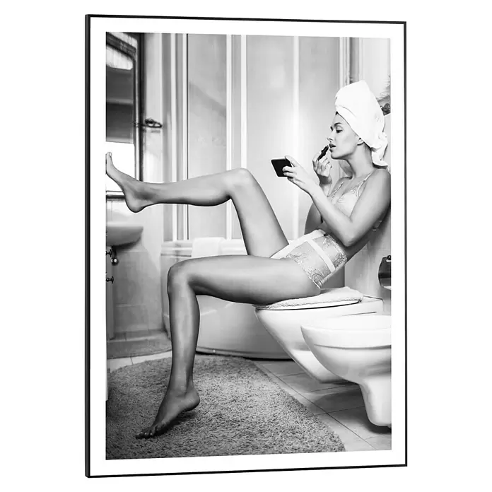 Reinders Bild Slim Frame Black - Getting Dressed, B x H: 50 x 70 cm - Eine Frau in Handtuch und Dessous trägt Lippenstift in einem Bad auf, auf einer Toilette sitzend mit einem Bein oben.