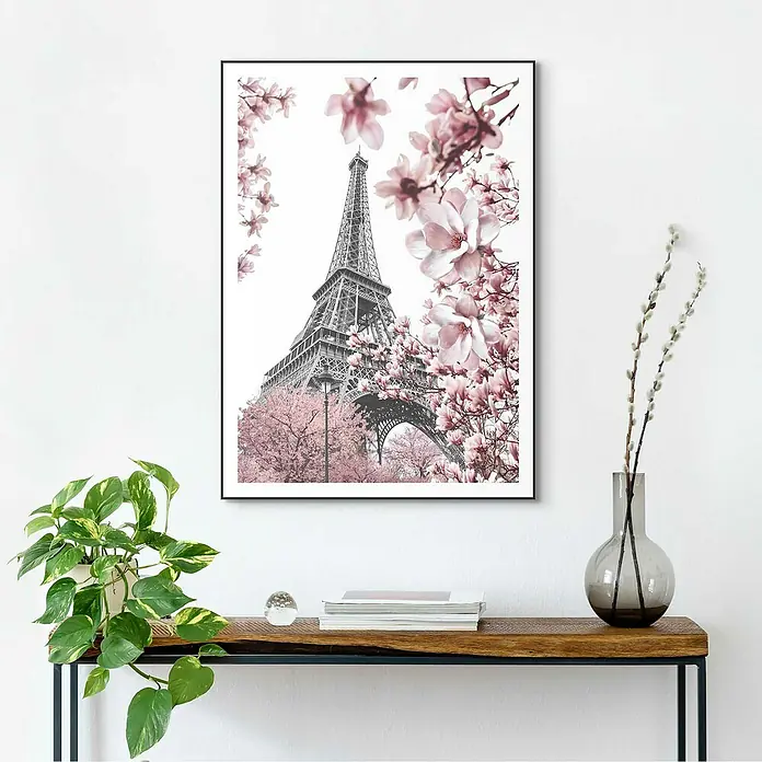Reinders Bild Slim Frame Black - Spring in Paris, B x H: 50 x 70 cm - Ein gerahmtes Bild der Eiffel Turm mit rosa Blumen an einer Wand, neben einer Topfpflanze und einer Vase auf einem Holztisch.