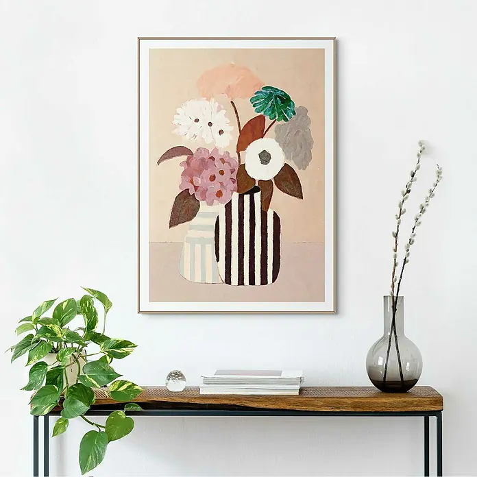 Reinders Bild Slim Frame Wood - Natural Setting, B x H: 50 x 70 cm - Ein gerahmtes Gemälde von Blumen in gestreiften Vasen hängt über einem Holztisch, der mit Büchern und Pflanzen dekoriert ist.