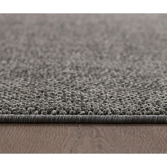 Flachgewebeteppich Loom - Grau, Durchmesser: 200 cm, 100 % Polypropylen - Nahaufnahme eines grauen Teppichs mit dunklem Rand auf einem Holzboden.