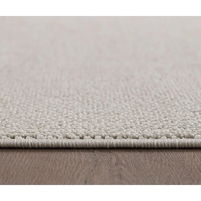 Flachgewebeteppich Loom - Creme, 230 x 160 cm, 100 % Polypropylen - Detailaufnahme eines beigen Teppichs auf einem Holzboden, der die Textur und die hochwertige Verarbeitung hervorhebt.