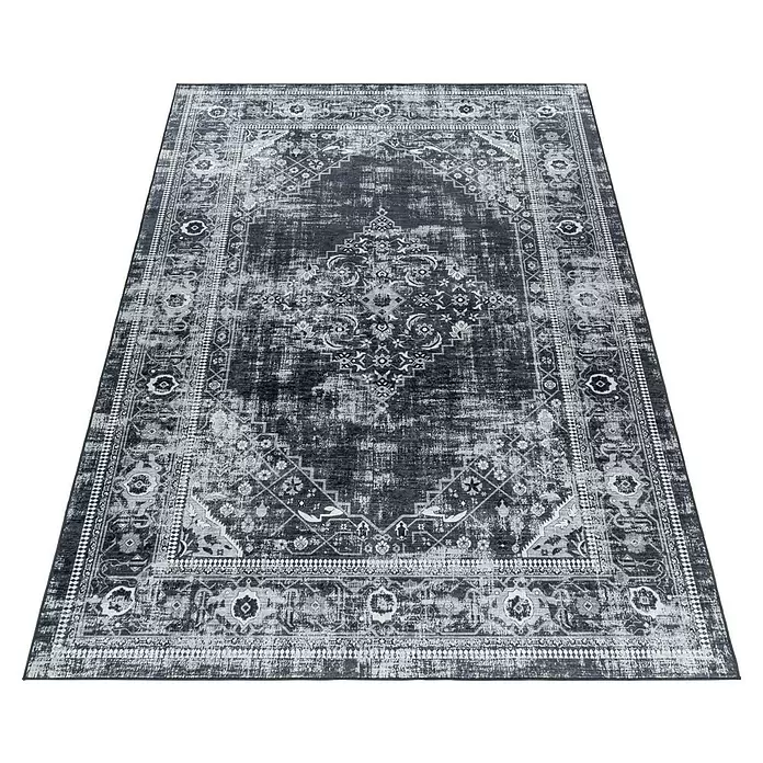 Flachgewebeteppich Fiesta - Schwarz/Grau, 290 x 200 cm, 100 % Polyester - Dunkelgrauer, abgenutzt wirkender Teppich mit traditionellem Muster und hellgrauen Akzenten, schräg von oben gesehen.