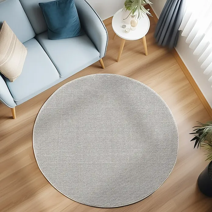 Flachgewebeteppich Loom - Creme, Durchmesser: 160 cm, 100 % Polypropylen - Ein heller, runder Teppich liegt unter einem blauen Sofa und einem kleinen Tisch, der das moderne Wohnzimmer gemütlich macht.