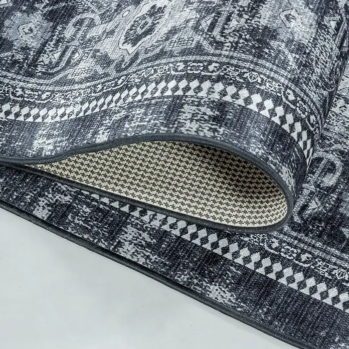 Flachgewebeteppich Fiesta - Schwarz/Grau, 290 x 200 cm, 100 % Polyester - Nahaufnahme eines stilvollen grauen Teppichs mit gewelltem Muster und detaillierter Unterseite, der Textur und Design hervorhebt.