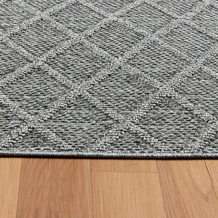 Outdoor-Teppich Patara V - Grau, 250 x 80 cm, 100 % Polypropylen - Nahaufnahme eines grauen Teppichs mit Rautenmuster, der auf einem Holzboden liegt. Der Teppich hat eine feine Textur.