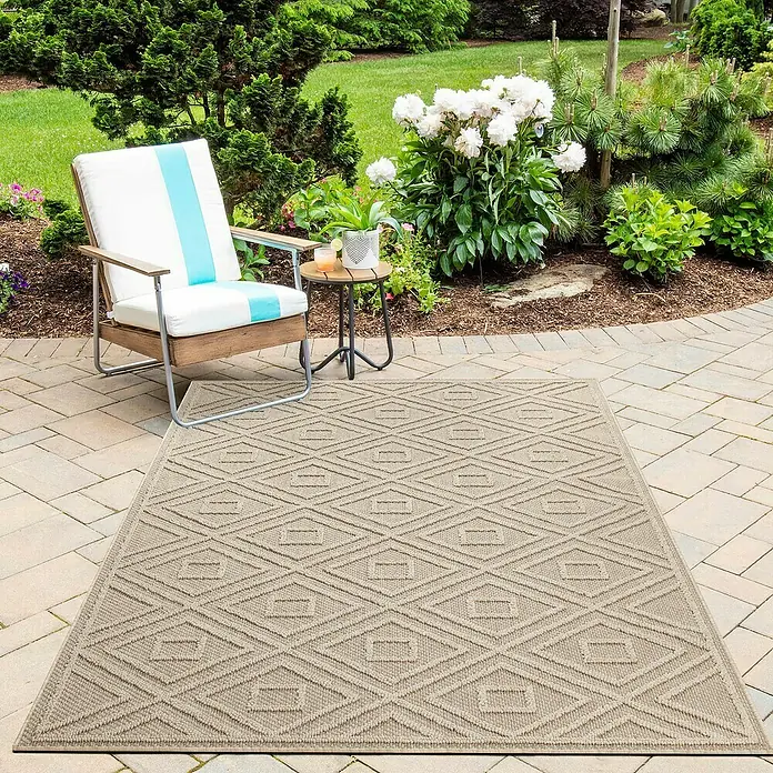 Outdoor-Teppich Patara III - Beige, 250 x 80 cm, 100 % Polypropylen - Bild einer rechteckigen, beigen Outdoor-Teppich mit einem geometrischen Rautenmuster auf einer Terrasse mit Gartenmöbeln.