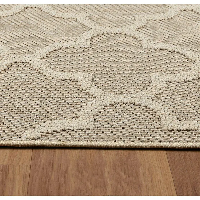 Outdoor-Teppich Patara IV - Beige, 340 x 240 cm, 100 % Polypropylen - Nahaufnahme eines beigen Outdoor-Teppichs mit einem geometrischen Muster auf einem Holzboden, der Textur und Stil vereint.
