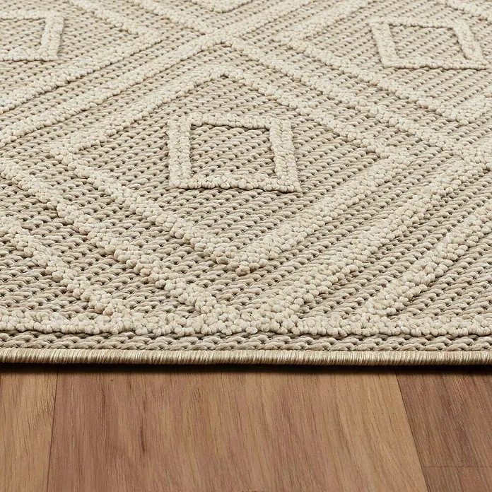 Outdoor-Teppich Patara III - Beige, 250 x 80 cm, 100 % Polypropylen - Nahaufnahme eines beigen Teppichs mit geometrischem Muster auf einem Holzboden, der Textur und Design des Teppichs hervorhebt.