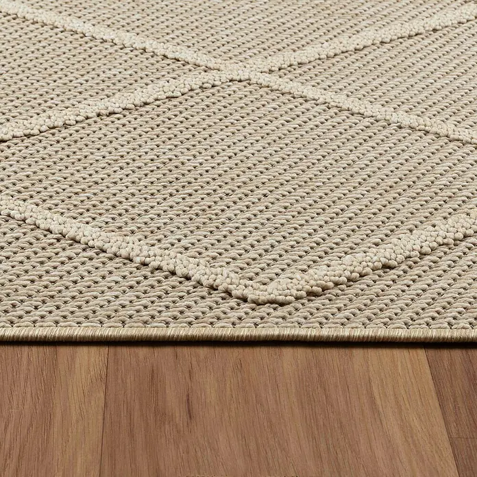 Outdoor-Teppich Patara II - Beige, 150 x 80 cm, 100 % Polypropylen - Nahaufnahme eines beigen Teppichs mit geometrischem Muster, der auf einem Holzboden liegt.