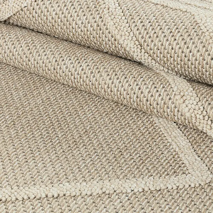 Outdoor-Teppich Patara I - Beige, 230 x 160 cm, 100 % Polypropylen - Detailansicht eines gerollten, beigen Teppichs mit gewebter Struktur, der Textur und Wärme ausstrahlt.