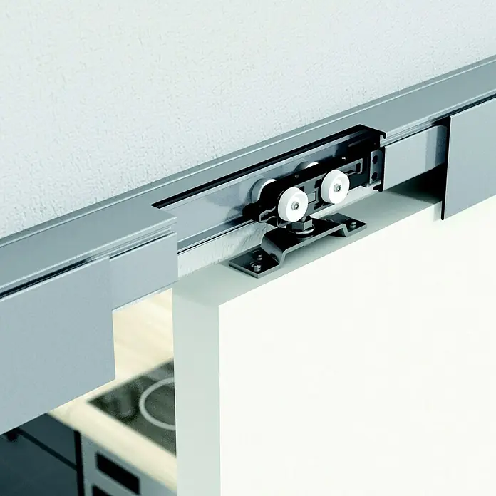 Kilsgaard Schiebetür-Komplettset 17/04 mit Beschlag 7 - 935 x 2.050 mm, Weiß, Wabe - Nahaufnahme eines Schiebetürbeschlags, der an einer weißen Tür und einer Schiene befestigt ist, die an einer weißen Wand montiert ist.