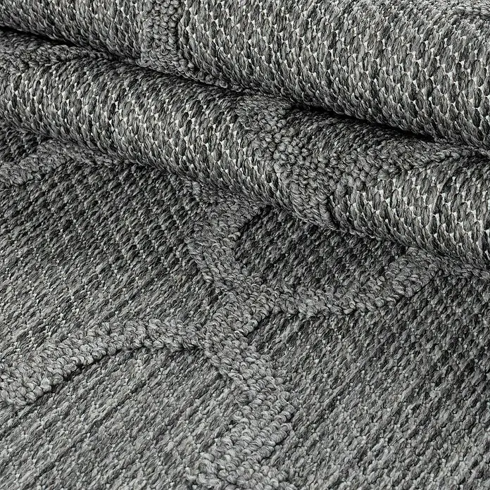 Outdoor-Teppich Patara IV - Grau, 200 x 140 cm, 100 % Polypropylen - Nahaufnahme eines grauen Teppichs mit gewebter Textur, der eine gemütliche und stilvolle Atmosphäre schafft.\n