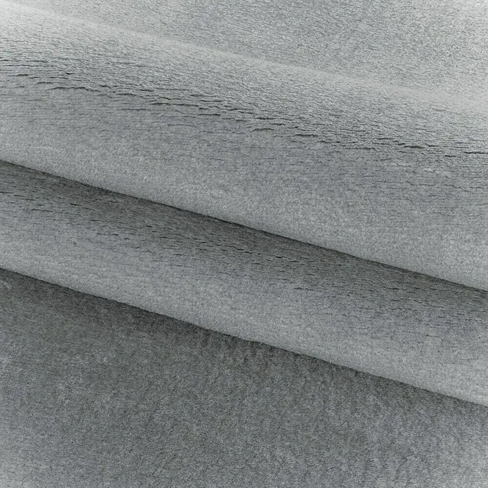 Kurzflorteppich SkySilber, 340 x 240 cm, 100 % Polyester - Nahaufnahme eines gestapelten, weichen grauen Stoffes, ideal für Textilien, Polster oder Bekleidung. Die Textur ist flauschig und einladend.
