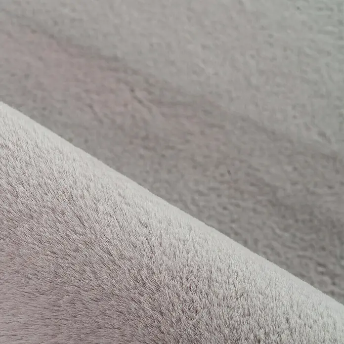 Hochflorteppich Pouffy - Beige, 110 x 60 cm, 100 % Polyester - Nahaufnahme eines grauen Stoffes mit weicher, flauschiger Textur, ideal für gemütliche Wohnaccessoires.