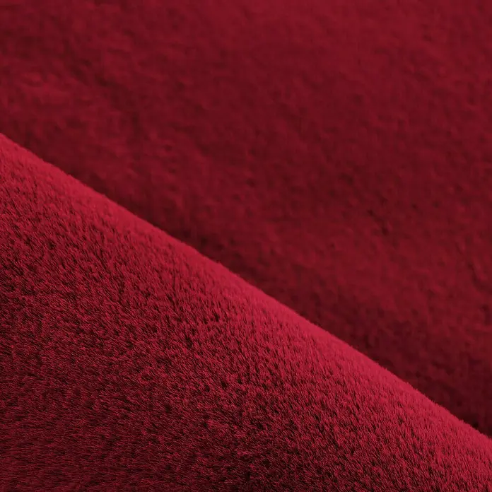 Hochflorteppich Pouffy - Rot, 290 x 200 cm, 100 % Polyester - Nahaufnahme von rotem Kunstfellstoff, der eine weiche und luxuriöse Textur zeigt, ideal für Bekleidung oder Heimdekorationsprojekte.