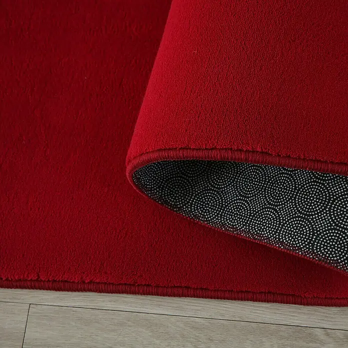 Kurzflorteppich Sky - Rot, 250 x 80 cm, 100 % Polyester - Nahaufnahme eines roten Teppichs mit rutschfester Unterseite.