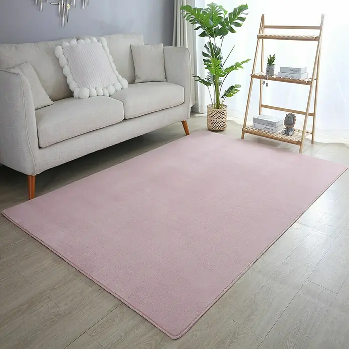 Kurzflorteppich Sky - Rosa, 150 x 80 cm, 100 % Polyester - Ein weicher, rosa Teppich liegt in einem hellen Wohnzimmer und sorgt für einen Hauch von Wärme und Komfort im Raum.