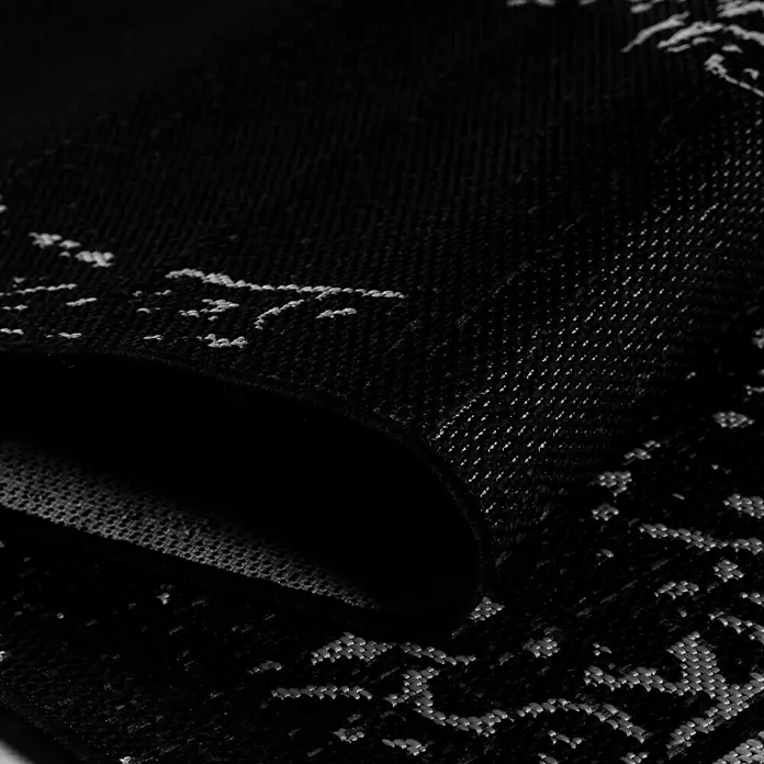 Outdoor-Teppich Sunny VIII - Schwarz, 170 x 120 cm, 100 % Polypropylen - Nahaufnahme eines schwarz-weißen Musters auf einer Stoffoberfläche, das eine elegante und moderne Textur zeigt.