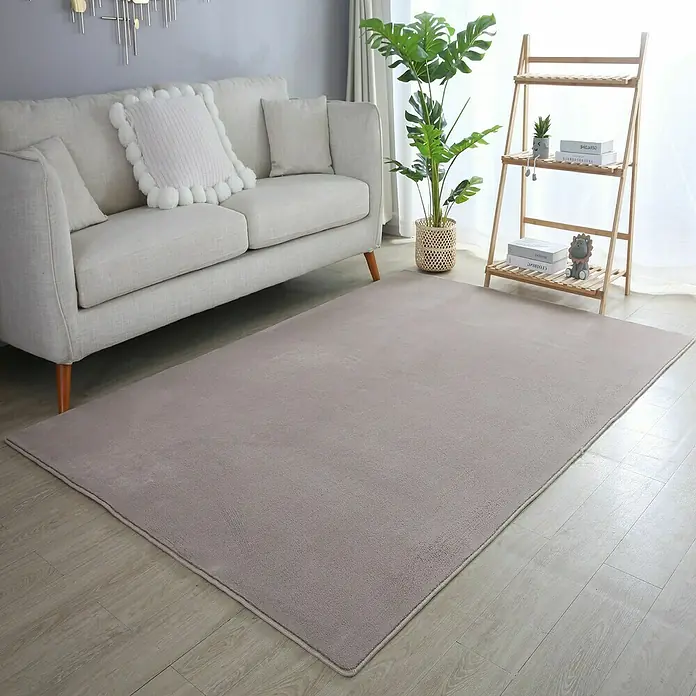 Kurzflorteppich Sky - Beige, 340 x 240 cm, 100 % Polyester - Ein modernes Wohnzimmer mit einem hellen Sofa und einem flauschigen, grauen Teppich, der den Raum optisch aufwertet.