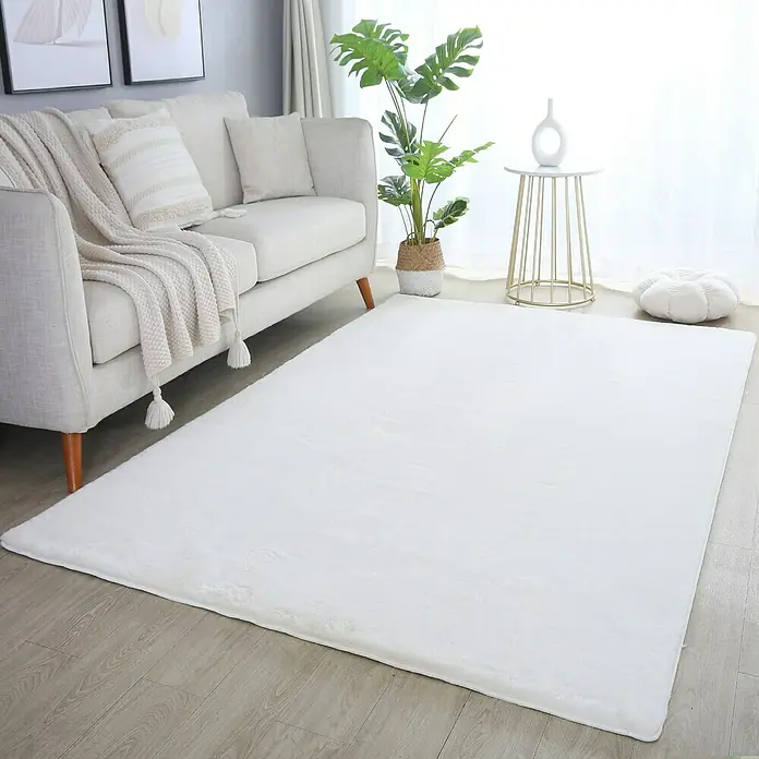 Hochflorteppich Pouffy - Creme, 200 x 140 cm, 100 % Polyester - Ein weicher, weißer Teppich liegt in einem hellen Wohnzimmer und sorgt für einen gemütlichen und einladenden Look.