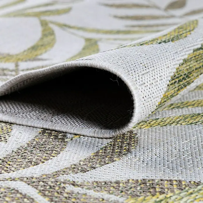 Outdoor-Teppich Sunny III - Beige, 250 x 80 cm, 100 % Polypropylen - Detailaufnahme eines grauen Teppichs mit Blättermuster, der aufgerollt ist und seine Textur zeigt.