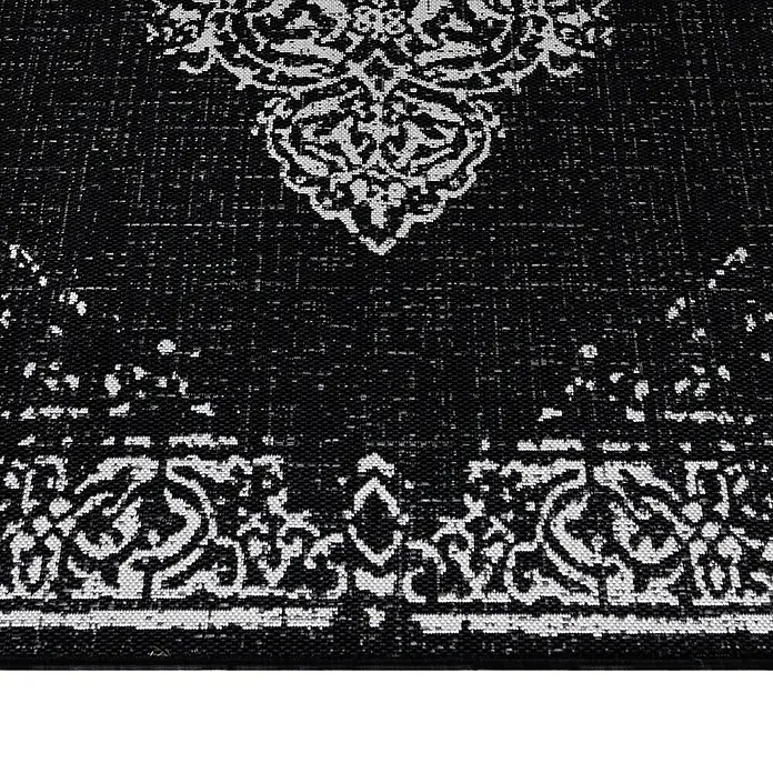 Outdoor-Teppich Sunny VIII - Schwarz, 170 x 120 cm, 100 % Polypropylen - Detailaufnahme eines schwarzen Teppichs mit weißem orientalischem Muster, das Textur und Design hervorhebt.