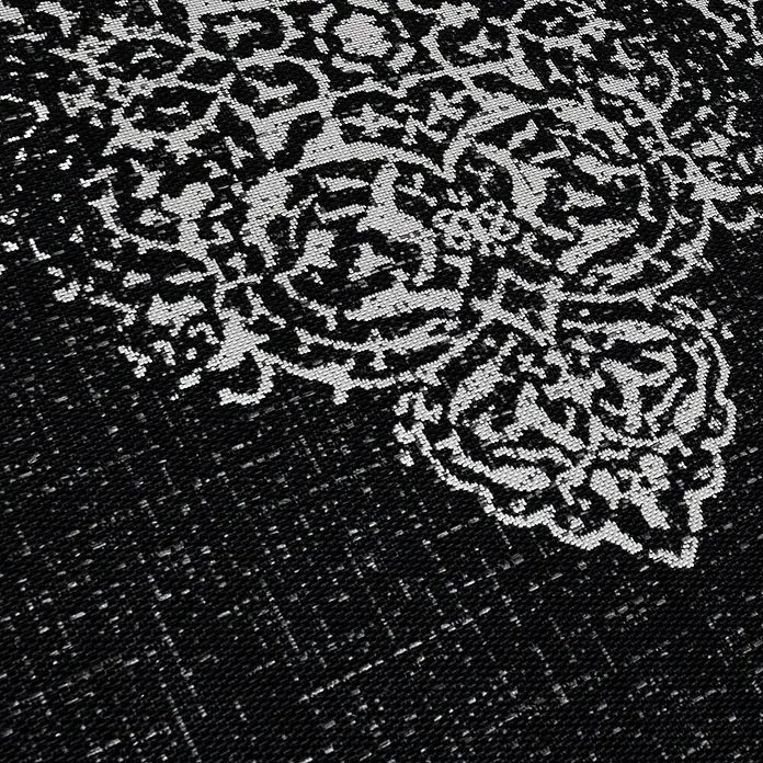 Outdoor-Teppich Sunny VIII - Schwarz, 170 x 120 cm, 100 % Polypropylen - Nahaufnahme eines eleganten schwarzen Teppichs mit einem kunstvollen weißen Muster, das dem Design eine raffinierte Note verleiht.