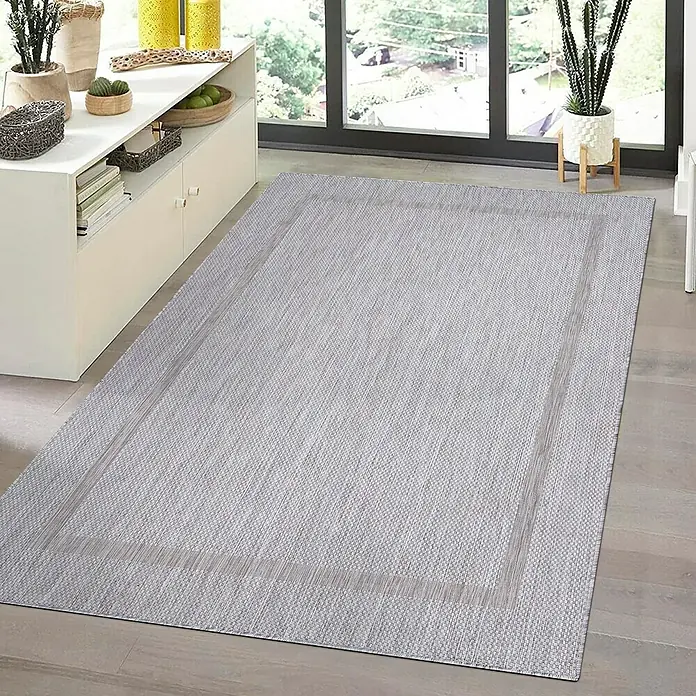 Outdoor-Teppich Relax - Silber, 230 x 160 cm, 100 % Polypropylen - Ein rechteckiger, grau melierter Teppich mit dekorativem Rand liegt auf einem Holzboden vor einer Fensterfront.