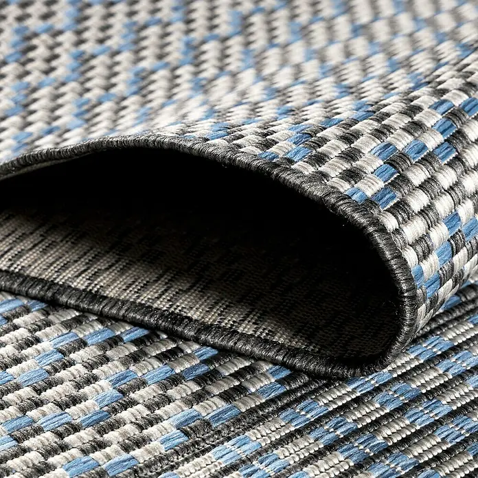 Outdoor-Teppich Sunny VII - Grau, 170 x 120 cm, 100 % Polypropylen - Nahaufnahme eines gewebten Teppichs mit blauem, grauem und schwarzem Karomuster, der eine dreidimensionale Textur und Detailgenauigkeit zeigt.