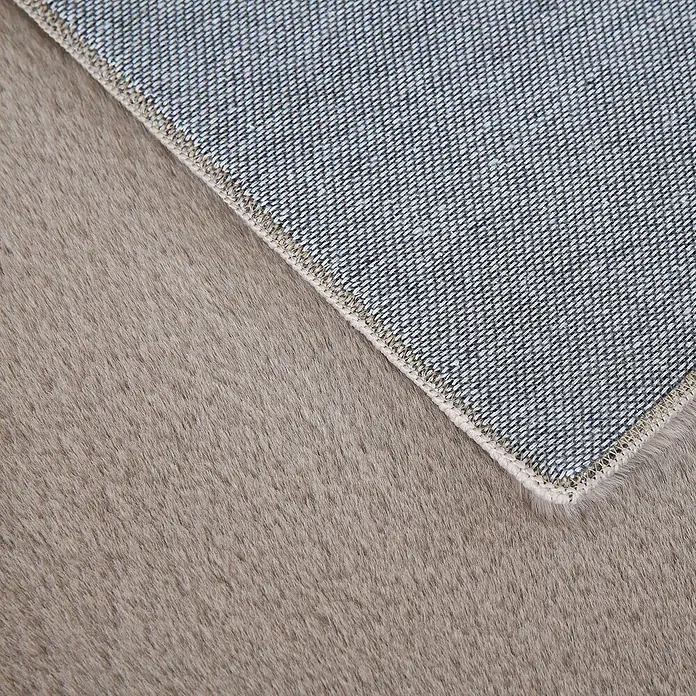 Hochflorteppich Pouffy - Beige, 110 x 60 cm, 100 % Polyester - Nahaufnahme von einem Teppich mit weicher Textur und gewebter Unterseite, ideal für Wohnräume und als dekoratives Element.