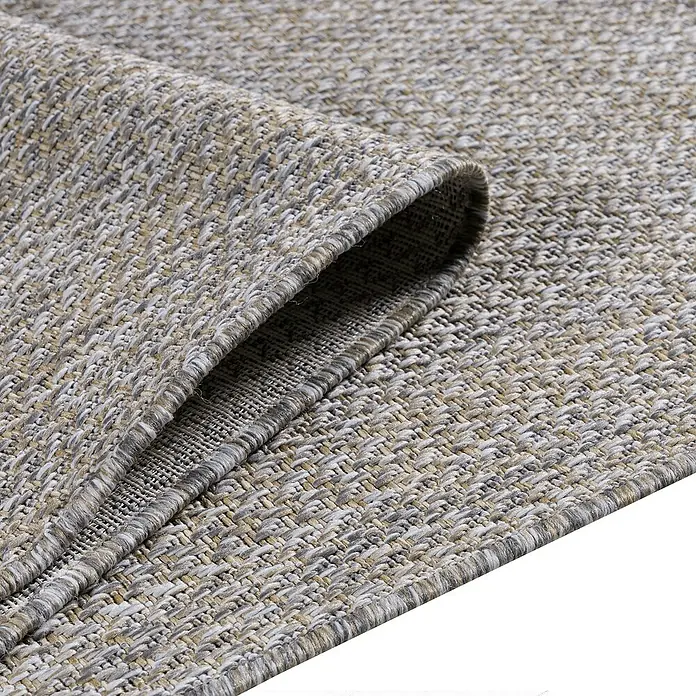 Outdoor-Teppich Zagora I - Beige, 170 x 120 cm, 100 % Polypropylen - Nahaufnahme eines beigefarbenen Teppichs mit einer gerollten Ecke, der seine Textur und Verarbeitung zeigt.