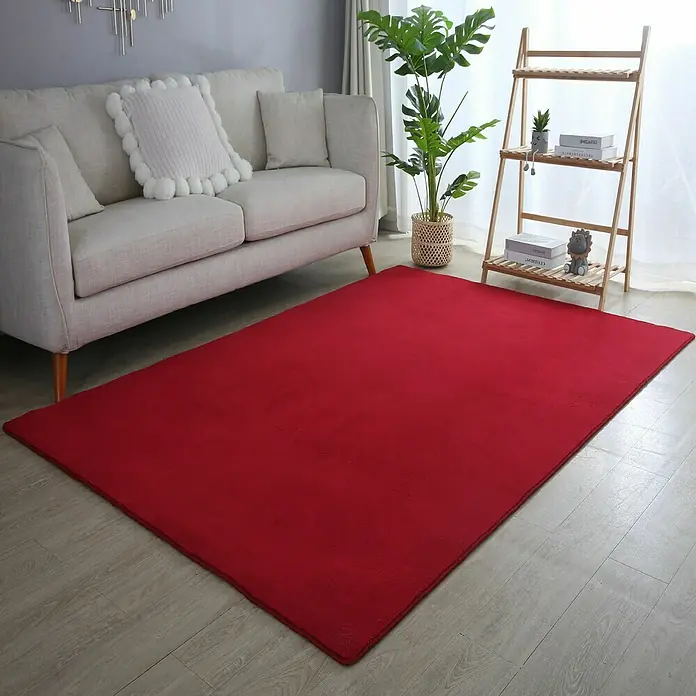 Kurzflorteppich Sky - Rot, 250 x 80 cm, 100 % Polyester - Ein roter Teppich liegt im Wohnzimmer unter einem Sofa und einem Regal, der dem Raum Wärme und Farbe verleiht.