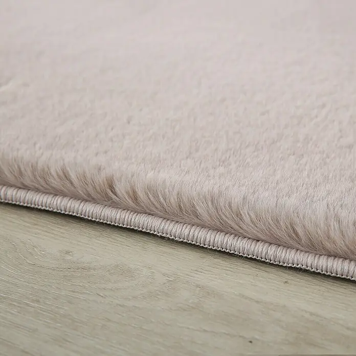 Hochflorteppich Pouffy - Beige, 110 x 60 cm, 100 % Polyester - Nahaufnahme eines flauschigen, rosa Teppichs, der die weiche Textur und die Detailgenauigkeit der Verarbeitung hervorhebt.