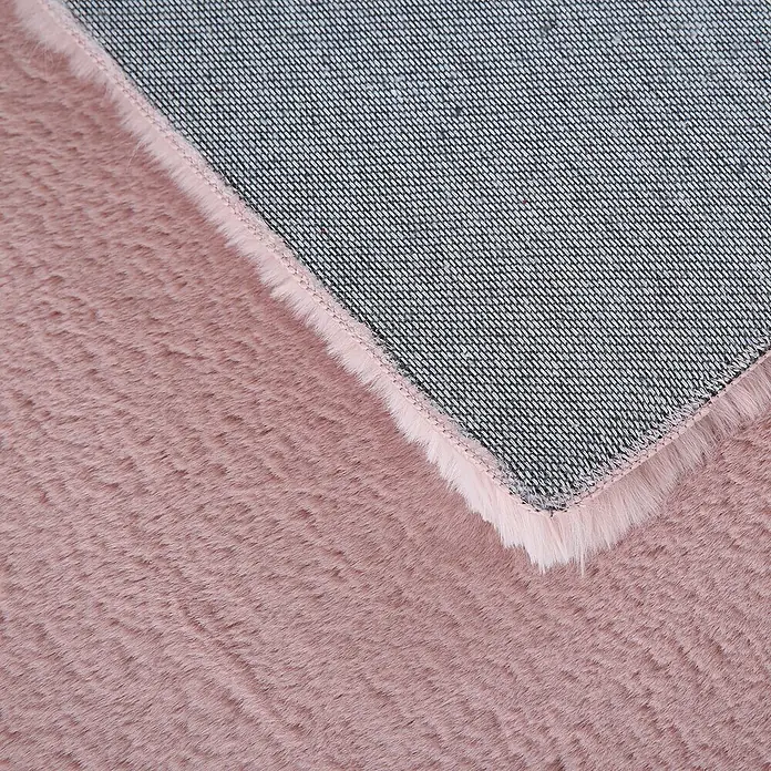 Hochflorteppich Pouffy - Rosa, 170 x 120 cm, 100 % Polyester - Nahaufnahme eines flauschigen, rosafarbenen Teppichs mit einer grauen, robusten Rückseite, die für Haltbarkeit sorgt.