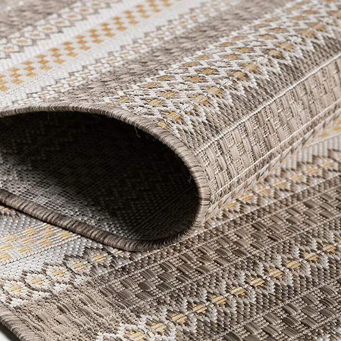 Outdoor-Teppich Sunny V - Beige, 150 x 80 cm, 100 % Polypropylen - Nahaufnahme eines dekorativen Outdoor-Teppichs mit Fransen und einem attraktiven Muster in Beige-, Gold- und Weißtönen.