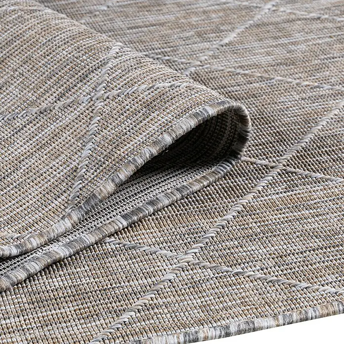 Outdoor-Teppich Zagora II - Beige, 170 x 120 cm, 100 % Polypropylen - Detailaufnahme eines beigen Teppichs mit Rautenmuster, der aufgerollt ist und seine Textur und Verarbeitung zeigt.